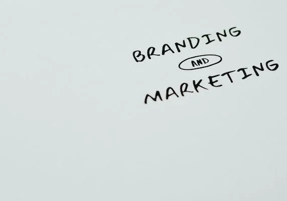 Handwritten text reading 'BRANDING AND MARKETING' in black on a light gray background