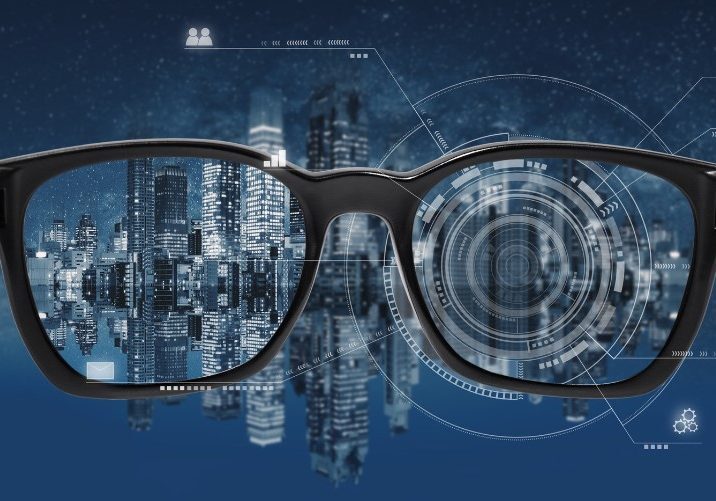 Smart glasses displaying futuristic cityscape and digital interface overlay against dark blue background